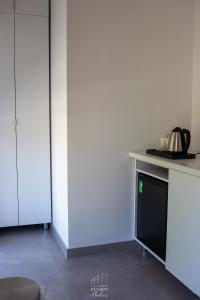 a kitchen with white cabinets and a counter top at Pansion Hukić B&B in Tuzla