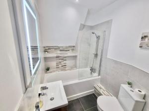 a white bathroom with a tub and a sink and a toilet at Lovely 1 Bed Apartment in Old Market Square in Nottingham