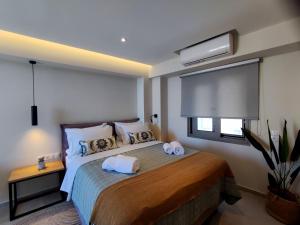 een slaapkamer met een bed met twee handdoeken erop bij PANORMUS Luxury House in Panormos Rethymno
