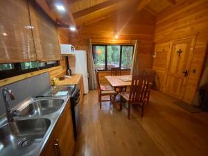 una cocina con fregadero y una mesa en una cabaña en Cabaña nueva en Pucón en Pucón