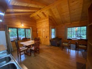 eine Küche und ein Esszimmer in einem Blockhaus mit einem Tisch und Stühlen in der Unterkunft Cabaña nueva en Pucón in Pucón