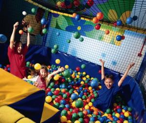 a man and two children playing in a ball pit at Pontins - Prestatyn Sands Holiday Park in Prestatyn