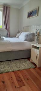 a bedroom with a large bed and a table at Green Garden meets Blue sea for 2 people in Dingle