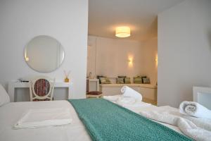 a white bedroom with a bed with towels on it at Levanta guesthouse in Schinoussa