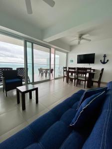 sala de estar con sofá azul y mesa en Departamentos frente al mar en Resort Playa Azul-Tonsupa, en Tonsupa