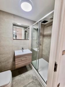 een badkamer met een douche, een wastafel en een toilet bij Luxurious Apartment in Nottingham Lace Market in Nottingham