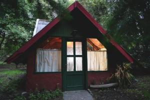 una pequeña casa roja y verde con ventana en Cabañas La Inesita en San Carlos de Bariloche