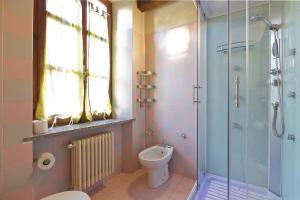 a bathroom with a toilet and a glass shower at Appartamenti Orta in Orta San Giulio