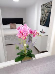 eine Vase voller rosa Blumen in einem Zimmer in der Unterkunft Casa Fortu La Palma in Los Llanos de Aridane