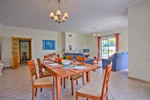 a dining room and living room with a table and chairs at Villa Solange by Villa Plus in Albufeira