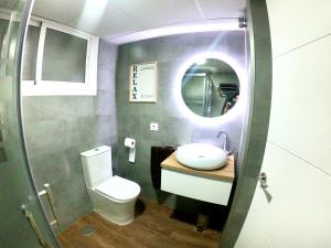 bagno con servizi igienici, lavandino e specchio di DELUXE TRIANA CENTER a Siviglia