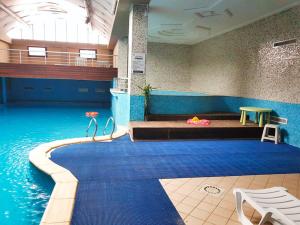 a room with a pool with a bed and a table at Hotel Raya Tichy in Tichi