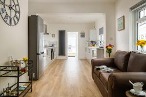 uma sala de estar com um sofá e uma cozinha em Fenton House - Modern, 4 Bedroom, Pets Accepted em Porthcawl