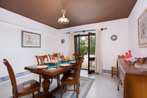 een eetkamer met een houten tafel en stoelen bij Villa Tupi by Villa Plus in Boliqueime