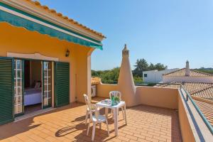 een patio met een tafel en stoelen op het dak van een huis bij Villa Boavista by Villa Plus in Boliqueime