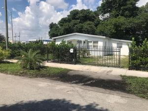 a fence in front of a white house at Bekahouse Hostel with parking, backyard and laundry in Miami