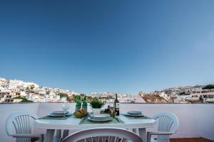 uma mesa e cadeiras brancas com vista para a cidade em GuestRooms by HOA em Albufeira