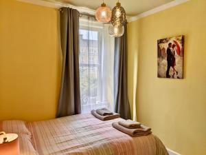 a bedroom with a bed and a window with towels on it at Cosy one bedroom flat in city center in Edinburgh