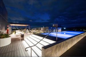 a swimming pool on the roof of a building at night at The Hamptons - Lux 2 Bed 2 Bath, Pool - Central Location in Canberra