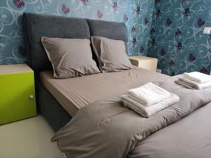 - un lit avec 2 serviettes assises au-dessus dans l'établissement CHEZ WL, à Luxembourg