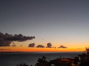 勒卡爾貝的住宿－Evasion Nord Caraïbe vue mer -plage 5 mn à pieds，天空中云云的海洋日落