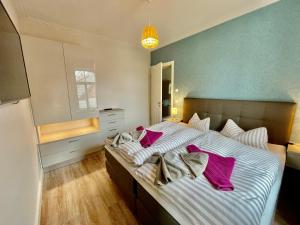 a bedroom with a large bed with purple pillows at Altstadtdomizil Wohnung Hygge in Borkum