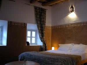 une chambre d'hôtel avec un lit et une fenêtre dans l'établissement Kasbah Iswan, à Kelaat-M'Gouna