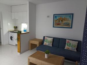 sala de estar con sofá azul y cocina en Bungalow Ca Margarita San Agustín, en San Agustín