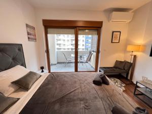 a bedroom with a bed and a balcony with a table at White Homes 16 - Master Quart in Podgorica