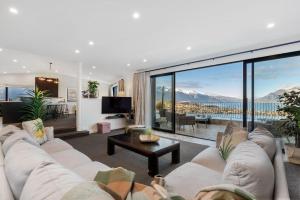 a living room with a couch and a large window at The Star of Queenstown Hill in Queenstown