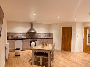 una cucina con tavolo e sedie in una stanza di Plumptons Farm Holiday Lodges a Colchester