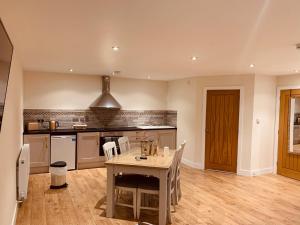 a kitchen with a table and chairs in a room at Plumptons Farm Holiday Lodges in Colchester
