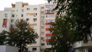 a tall white building with trees in front of it at Atlas Accommodation Studio Romana de Lux in Bucharest