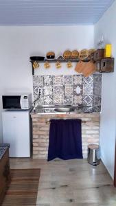 cocina con fregadero y fogones horno superior en Studio no Centro de São Joaquim/SC, en São Joaquim
