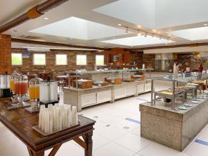 a restaurant with a large kitchen with tables and counters at Buzios Beach Resort Residencial super luxo 1307 in Búzios