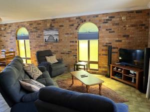 a living room with a couch and a tv at 10 Coora Court Rainbow Beach in Rainbow Beach