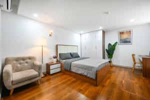Spring Hill Apartment -The High Class في مدينة هوشي منه: غرفة نوم بسرير وكرسي ومكتب