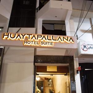 a hotel sign on the front of a building at Hotel Huaytapallana suites in Huancayo
