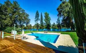 a swimming pool on a deck next to a lake at Luxury Riverside Estate - 3BR Home or 1BR Cottage or BOTH - Sleeps 14 - Swim, fish, relax, refresh in Anderson