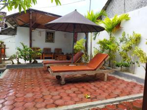 a patio with a chair and an umbrella at Pantai Bungalow Lembongan Island in Nusa Lembongan
