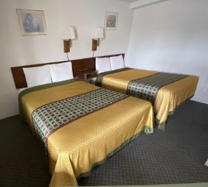 dwa łóżka siedzące obok siebie w pokoju w obiekcie Kansan Motel w Liberal