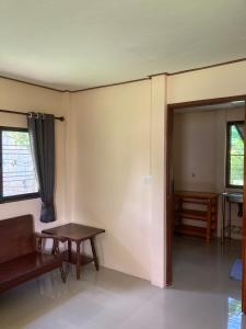 Una habitación con un sofá y una mesa y una puerta. en Baanpak Chomdoi, en Nan