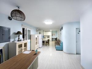 a living room with a kitchen and a dining room at Daora guesthouse in Garapan