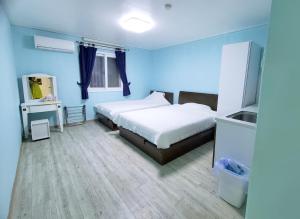 Dormitorio azul con cama y espejo en Daora guesthouse, en Garapan