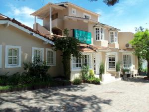 a building with a sign in front of it at Hostería Costa Bonita in Villa Gesell