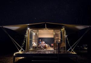 a couple sitting in a tent at night at Cooinda Lodge Kakadu in Jabiru