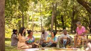 a group of people sitting on the grass in a park at Cooinda Lodge Kakadu in Jabiru