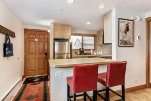 a kitchen with two red chairs and a counter at 1 Bedroom Antlers Vacation Rental With Incredible Slopeside Views And Just A Short Walk To Gondola And Lionshead Village in Vail