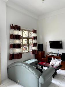 a living room with a couch and a window at Villa Bukit Indah in Berastagi