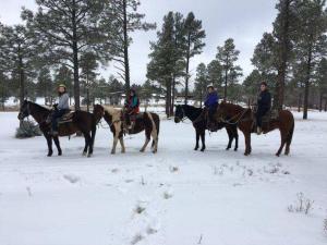 a group of people riding horses in the snow at Adair Springs Cabin in Pinetop-Lakeside